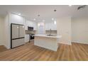 Modern kitchen with island, stainless steel appliances, and white cabinets at 4829 Jenny Way, New Port Richey, FL 34652