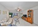 Living room with tiled floors, floral couch, and wood cabinet at 5557 Baywater Dr, Tampa, FL 33615