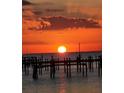 Silhouetted pier and sunset over the water at 6504 Surfside Blvd # 5, Apollo Beach, FL 33572