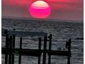 Stunning sunset over calm water with a pier in the foreground at 6504 Surfside Blvd # 5, Apollo Beach, FL 33572