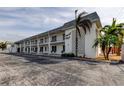 Exterior view of Sunset Plaza, a light-colored building with balconies and palm trees at 680 71St Ave # 14, St Pete Beach, FL 33706