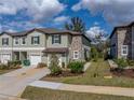 Desirable townhome displaying a stone accent wall, attached garage, and well-kept landscaping in a prime location at 6972 Ripple Pond Loop, Zephyrhills, FL 33541