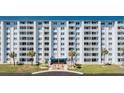 Condo building's front exterior with palm trees at 7 Elgin Pl # 502, Dunedin, FL 34698