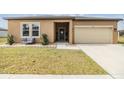 Tan house with a two-car garage and small front yard at 701 Garden Oaks Sq, Seffner, FL 33584