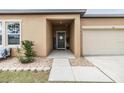 Front entrance with covered porch and a gray door at 701 Garden Oaks Sq, Seffner, FL 33584