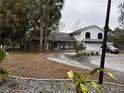 Two-story house with a curved driveway and palm trees at 8814 Mill Creek Ln, Hudson, FL 34667