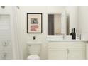 Clean bathroom with white vanity, shower, and vintage-style artwork at 9377 Runaway Breeze Dr, Land O Lakes, FL 34637