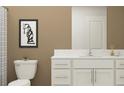 Modern bathroom with white vanity, beige walls, and a white toilet at 12215 Radiant Gem Trl, Parrish, FL 34219