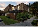 Tan two-story townhome with wood fence and tropical landscaping at dusk at 12746 Wood Trail Blvd, Tampa, FL 33625