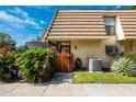 Tan townhome with wood fence, tropical plants, and AC unit at 12746 Wood Trail Blvd, Tampa, FL 33625