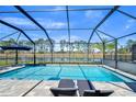 Relaxing screened-in pool with lounge chairs and water view at 14834 Paddock Pond Ave, Lithia, FL 33547