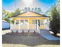 Inviting yellow house with white porch and steps leading to the entrance at 1913 E Wilder Ave, Tampa, FL 33610