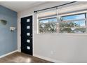 Bright entryway with modern dark door and wood-look flooring at 218 W Seneca Ave, Tampa, FL 33612