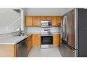 Kitchen with wood cabinets, stainless steel appliances, and tile floor at 2552 Glenrise Pl, Wesley Chapel, FL 33544