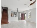 Bright living room with tile floors, staircase, and kitchen view at 2552 Glenrise Pl, Wesley Chapel, FL 33544