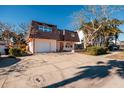 Two-story home with attached garage and mature landscaping at 3118 S Maritana Dr, St Pete Beach, FL 33706