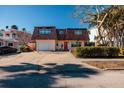 Two-story house with attached garage, and a red door at 3118 S Maritana Dr, St Pete Beach, FL 33706