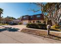 Two-story house with attached garage, and a red door at 3118 S Maritana Dr, St Pete Beach, FL 33706