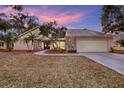 House exterior at dusk showcasing landscaping and garage at 4604 Westford Cir, Tampa, FL 33618