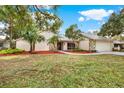 One-story home with a stone facade and mature trees at 4604 Westford Cir, Tampa, FL 33618