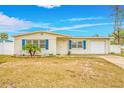 Newly painted light yellow ranch home with blue accents at 5810 Town N Country Blvd, Tampa, FL 33615