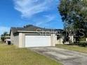 Single-story home with attached garage and grassy yard at 6802 Seaview Way, Tampa, FL 33615