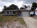 Newly renovated home with gray exterior, landscaped lawn, and attached garage at 895 64Th S Ave, St Petersburg, FL 33705