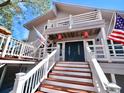 Two-story home's front entrance with stairs and charming details at 9934 Peninsular Dr, Gibsonton, FL 33534