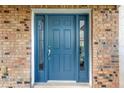 Blue front door with sidelights and brick surround at 10112 Haverhill Ridge Dr, Riverview, FL 33578