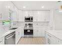 Modern kitchen featuring white shaker cabinets, quartz countertops, and stainless steel appliances at 10971 90Th Ave, Seminole, FL 33772
