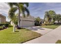 Tan house with palm trees and a neatly manicured lawn at 12311 Silton Peace Dr, Riverview, FL 33579