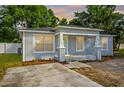 Newly renovated house with a gray exterior, a white door, and a small front porch and driveway at 12419 Lamont Ave, New Port Richey, FL 34654