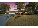 House exterior at dusk with a spacious yard at 12620 3Rd Isle, Hudson, FL 34667