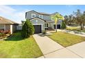 Two-story house with a green exterior, two-car garage, and palm tree at 13458 Graham Yarden Dr, Riverview, FL 33579