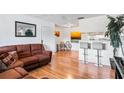 Bright living room with hardwood floors and a brown leather sectional sofa at 1400 Gandy N Blvd # 506, St Petersburg, FL 33702