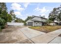 House with gray siding, attached garage, and a large driveway at 1534 Wexford N Dr, Palm Harbor, FL 34683