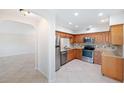 Condo kitchen with wood cabinets, granite counters, and stainless steel appliances at 301 Cordova Grn, Seminole, FL 33777