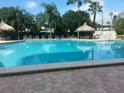 Inviting swimming pool with lounge chairs and thatch umbrellas at 400 Island Way # 1508, Clearwater Beach, FL 33767