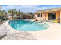 Kidney-shaped swimming pool in backyard with surrounding patio at 404 87Th Ave, St Pete Beach, FL 33706