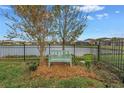 Landscaped backyard with a bench overlooking a lake at 6216 Kevesta Ave, Palmetto, FL 34221