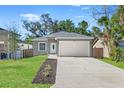 Newly built home features a gray exterior, white garage door, and a neatly landscaped front yard at 1584 S Washington Ave, Clearwater, FL 33756