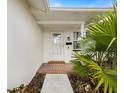 Front entrance with tiled porch and landscaping at 1768 Algonquin Dr, Clearwater, FL 33755