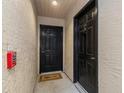 Apartment entry with two black doors and a welcome mat at 2400 Feather Sound Dr # 913, Clearwater, FL 33762