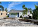 White bungalow with a blue door, green shutters, and a well-maintained lawn at 2660 Miriam S St, Gulfport, FL 33711