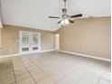 Bright living room featuring tile floors and french doors at 2715 Narcissus Dr, Holiday, FL 34691