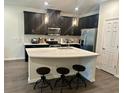 Modern kitchen with dark cabinetry, white countertops, and stainless steel appliances at 2878 Grand Kemerton Pl, Tampa, FL 33618