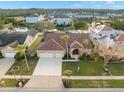 Bird's-eye view of a tan house, two-car garage, and neighborhood at 3190 Shoreline Dr, Clearwater, FL 33760