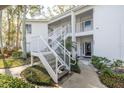 Condo building exterior with white stairs and landscaping at 3578 Indigo Pond Dr, Palm Harbor, FL 34685