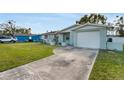 Light blue single-story home with a well-maintained lawn and a driveway leading to the attached garage at 5600 Bayou Grande Ne Blvd, St Petersburg, FL 33703