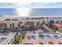 Aerial view showing condo building, parking, and beach at 7466 Bayshore Dr # 406, Treasure Island, FL 33706